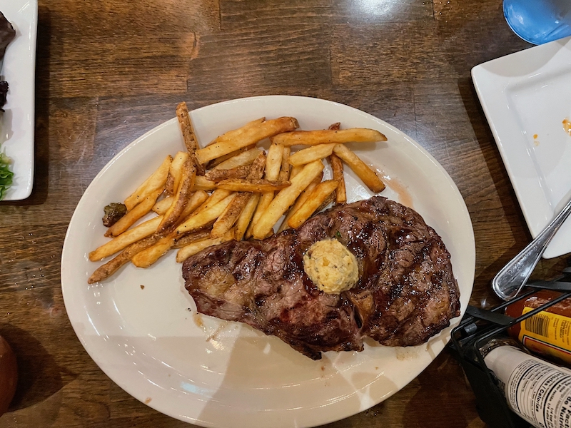 Grilled ribeye steak with fries and herb butter at Brick and Barrel Leesburg