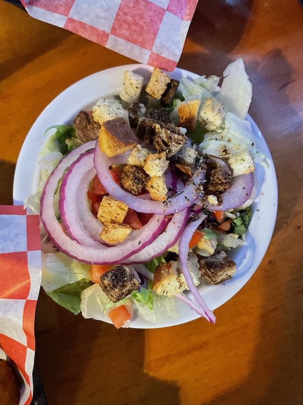 Fresh house salad with tomato, red onion, vegetables, and croutons